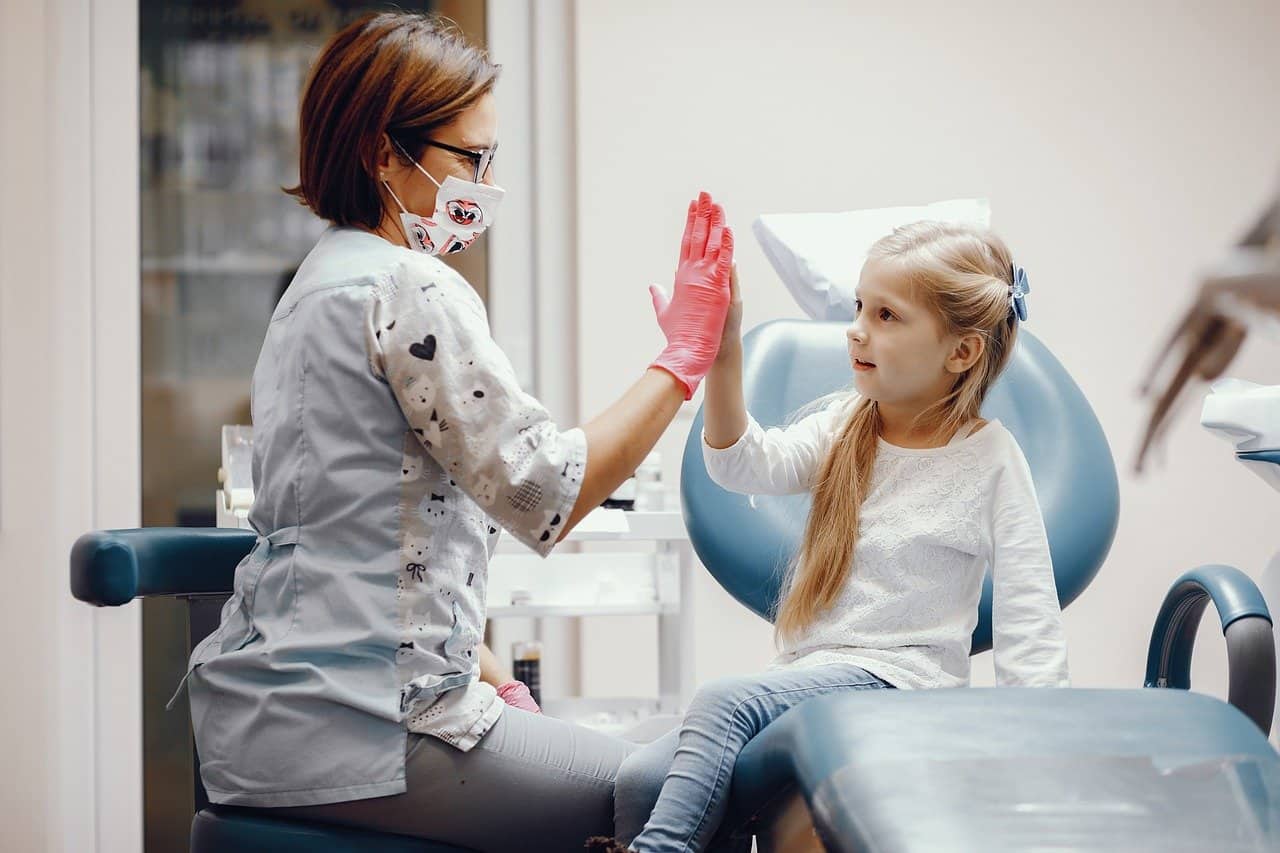 A child giving their dentist a high five